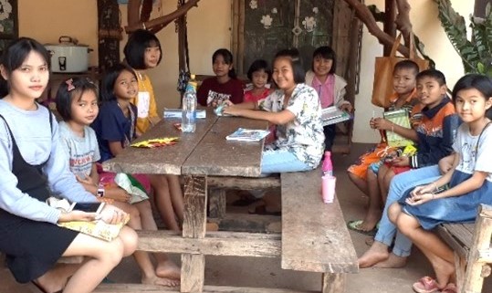 A group of children sitting at a table

Description automatically generated