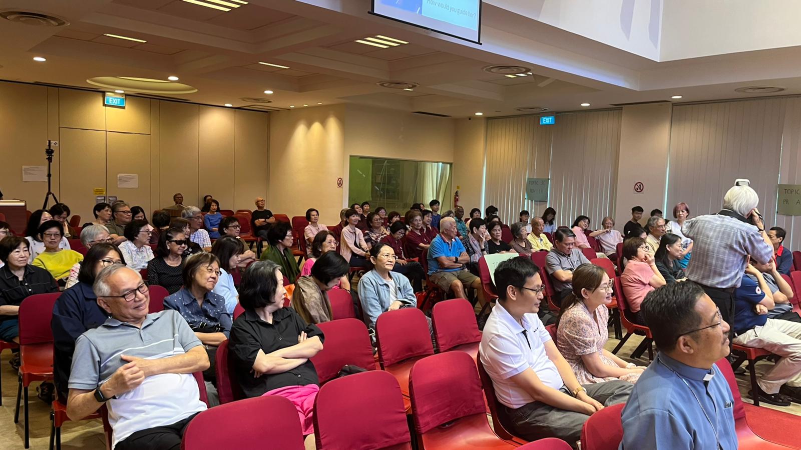 A group of people sitting in a room
AI-generated content may be incorrect.