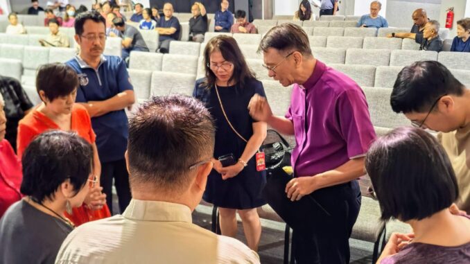 lutheran church in singapore hosts day of prayer in july 2026, with speaker bishop anthony loh praying with a group
