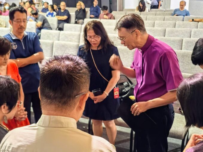 lutheran church in singapore hosts day of prayer in july 2026, with speaker bishop anthony loh praying with a group